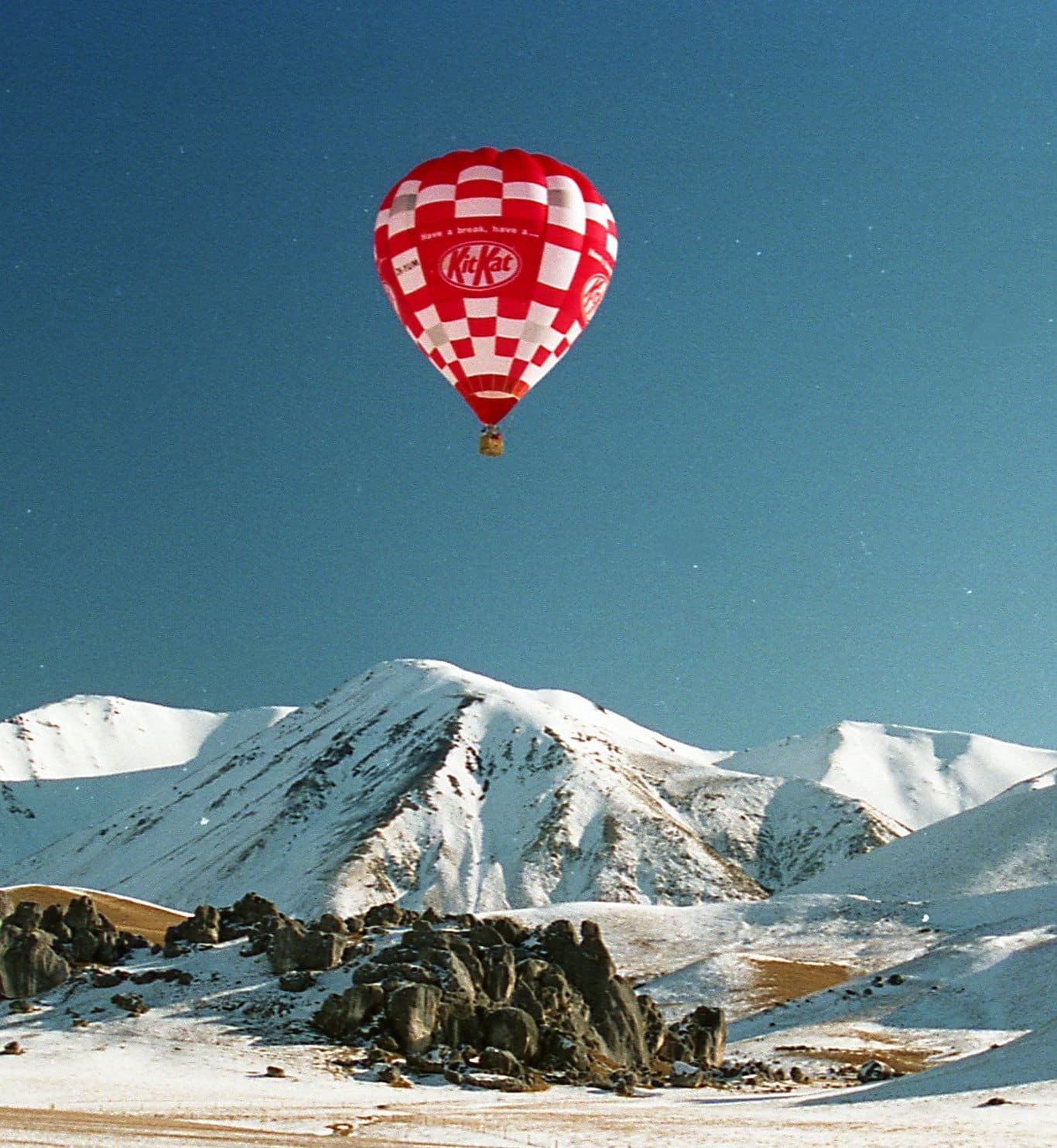 Kit-Kat brand hot air balloon over snowy mountains