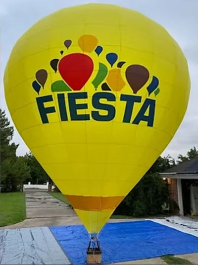 RC hot air balloon in bright yellow with Fiesta branding about to take off
